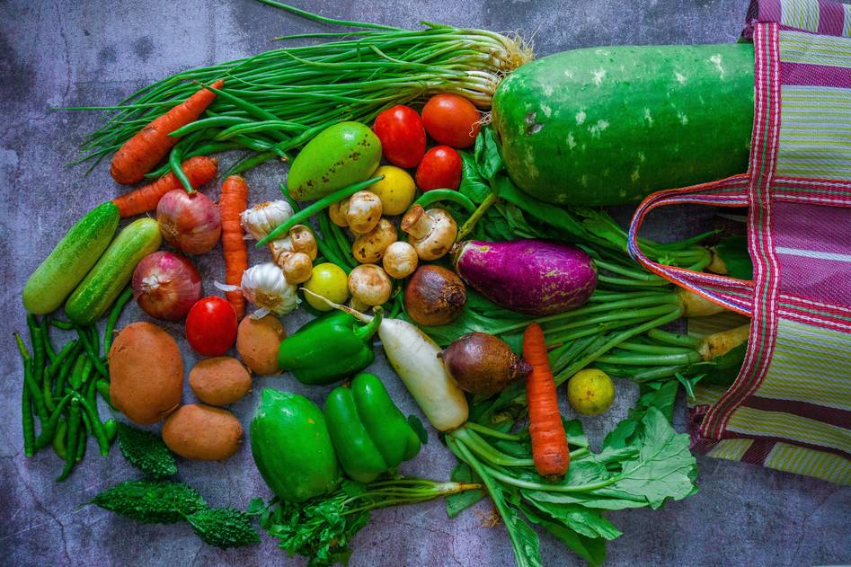 Fresh green vegetables and whole grains on a wooden table