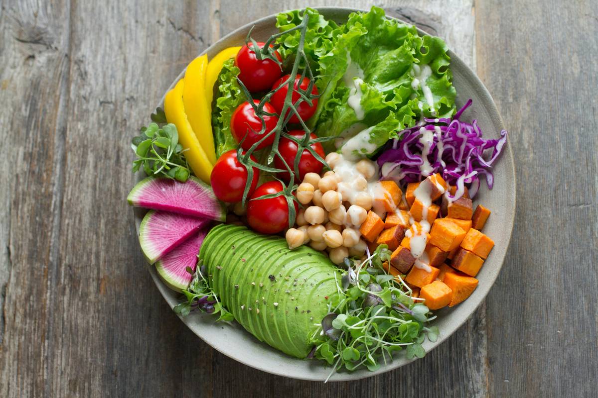 A colorful bowl of fermented gut-friendly foods like kimchi, yogurt, sauerkraut, and kefir that support a healthy gut